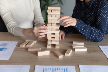 Çeşitli meslektaşları ahşap bloklardan kule inşa ederken kapat