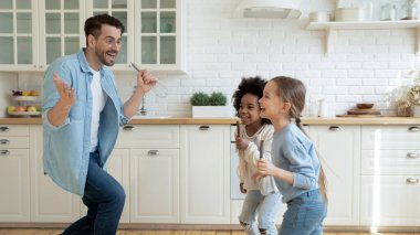 Mutfakta eğlenen iki farklı kızı olan çok mutlu bir baba.