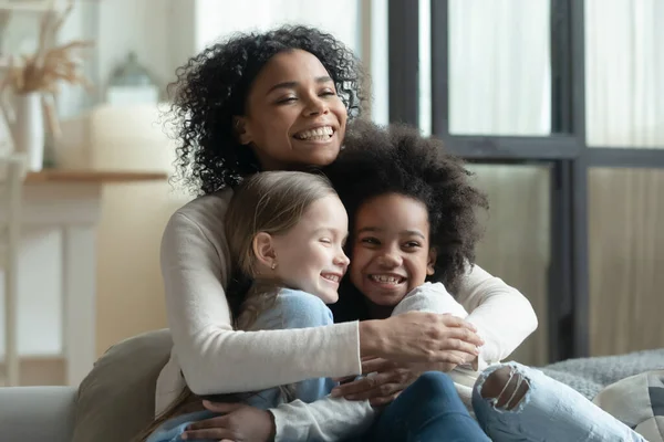 Mulher afro-americana super feliz abraçando duas filhas pequenas — Fotografia de Stock