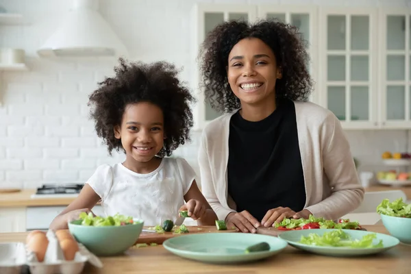 Afro-Amerikan annesi ve kızı yemek pişirirken çekilmiş bir portre. — Stok fotoğraf