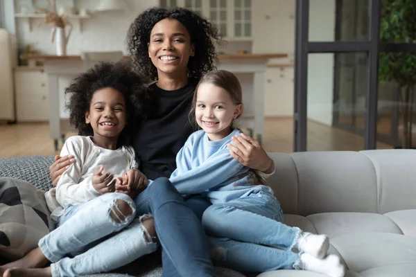 Retrato madre afroamericana abrazando a dos hijas pequeñas, familia multirracial — Foto de Stock