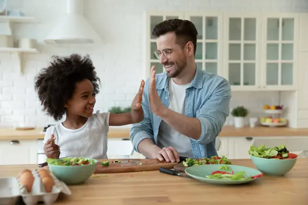 Vater und afroamerikanische Mädchen geben High Five in der Küche — Stockfoto