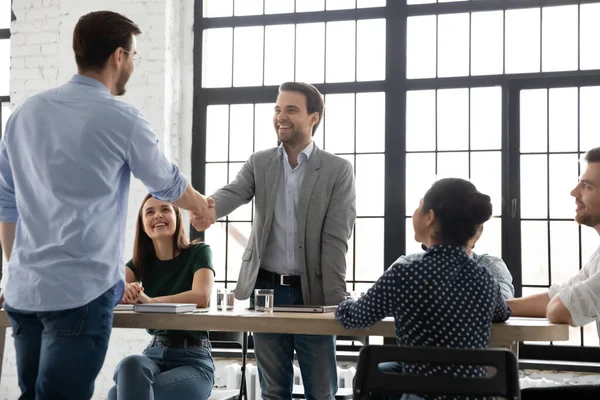 Chefe handshaking com feliz jovem trabalhador cumprimentando com promoção — Fotografia de Stock