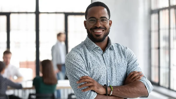 Líder negro confiante em pé no escritório da empresa moderna sentindo-se orgulhoso — Fotografia de Stock