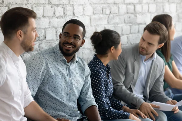 Personas multiétnicas positivas que pasan tiempo en la cola conociéndose hablando — Foto de Stock