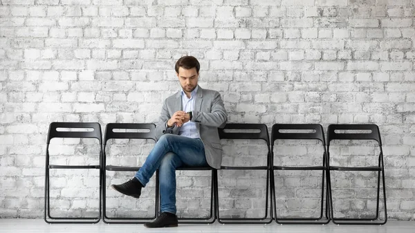 Joven solicitante de empleo sentado en la sala de la empresa de control de tiempo — Foto de Stock