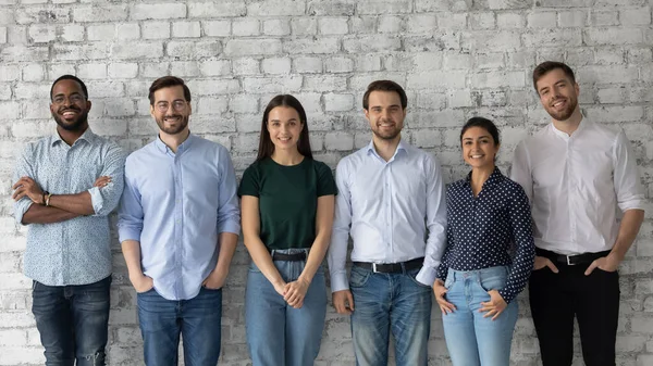 Jeunes gens d'affaires diversifiés prospères debout en rangée regardant la caméra — Photo