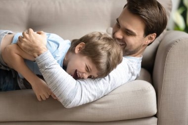 Sevinçten havalara uçar baba oğul kucaklaşır, kanepede yatarlar.