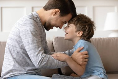 Sevinçli baba ve küçük oğul alınlarına dokunuyor, eğleniyorlar.