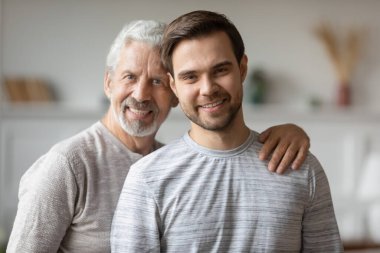 Yetişkin baba ve oğulun kucaklaşması.