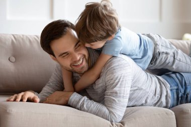 Mutlu baba oğul kucaklaşması, kanepede yatma.