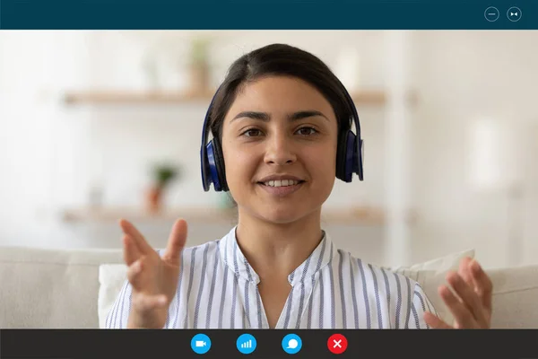 Young happy indian ethnicity businesswoman in headphones holding video call.