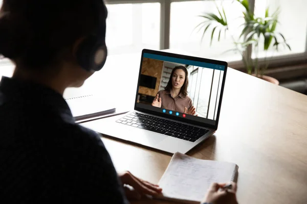 Concentrato giovane donna in cuffie coinvolti nella classe di educazione online. — Foto Stock