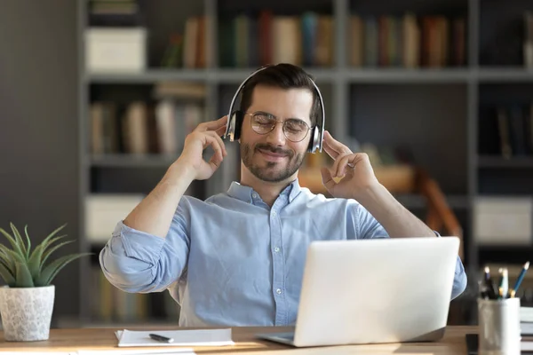 Serene office employee listen favourite music through modern wireless headphones — Stock Photo, Image