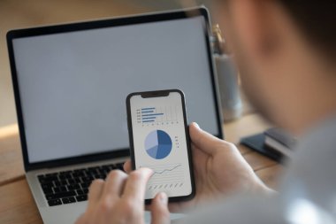 İşadamı, bilgisayar ve akıllı telefonu finansal verilerle senkronize eder
