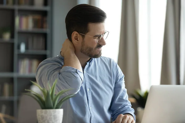 Man sitter på arbetsplatsen skrivbord beröring hals känsla smärta — Stockfoto