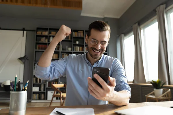 Man op zoek naar smartphone scherm lezen bericht voelt gelukkig — Stockfoto