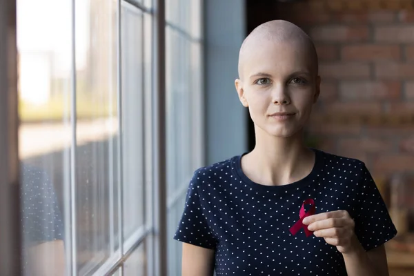 Retrato de mulher sem pêlos diagnosticado com oncologia segurando fita escarlate — Fotografia de Stock