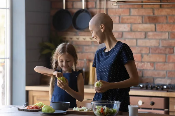 Gelukkig moeder kanker patiënt en dochter koken in de moderne keuken — Stockfoto