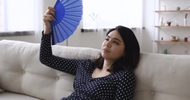 Stressato surriscaldato millenario asiatico misto razza donna utilizzando carta fan. — Video Stock