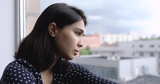 Tänksam koreansk asiatisk kvinna som tittar ut genom fönstret. — Stockvideo