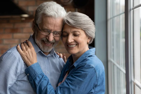 Primer plano feliz pareja madura abrazando con los ojos cerrados —  Fotos de Stock