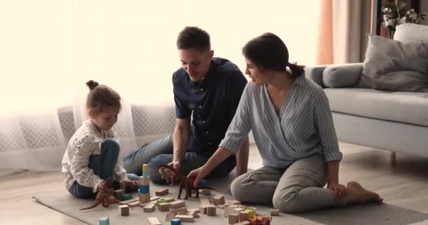 Gezin met kleine dochter spelen met speelgoed in de woonkamer — Stockvideo