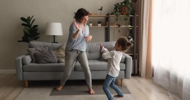 Mutter und kleine entzückende Tochter tanzen im Wohnzimmer — Stockvideo