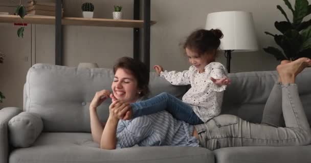 Daughter sit on mommy back family play together at home — Stock Video
