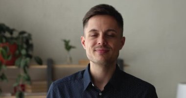 Kameraya gülümseyen 30 'lu yaşlardaki yakışıklı bir adamın portresi.