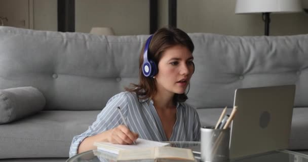 Woman wear headphones talk to teacher learns english by videocall — Stock Video