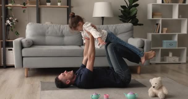 家庭で楽しみを持っている家族は小さな娘と遊ぶ — ストック動画