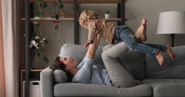 Madre cariñosa acostada en el sofá jugar con el hijo preescolar — Vídeo de stock
