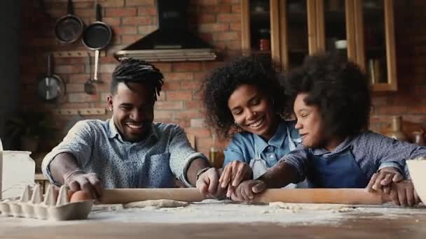 Familia africana feliz cocinar juntos aplanar la masa utilizando rodillo — Vídeo de stock