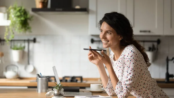 Smiling woman record voice message on cellphone