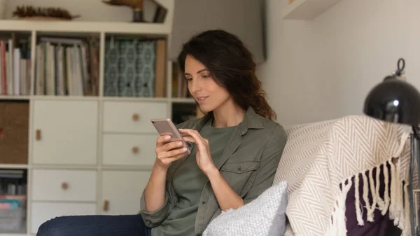 Caucasian woman relax on couch using cellphone