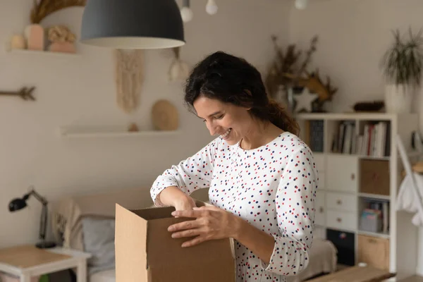 Excited young woman unpack postal box with order — Stock Photo, Image