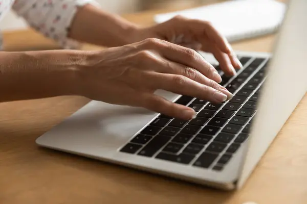 Close up of woman typing on modern laptop keyboard