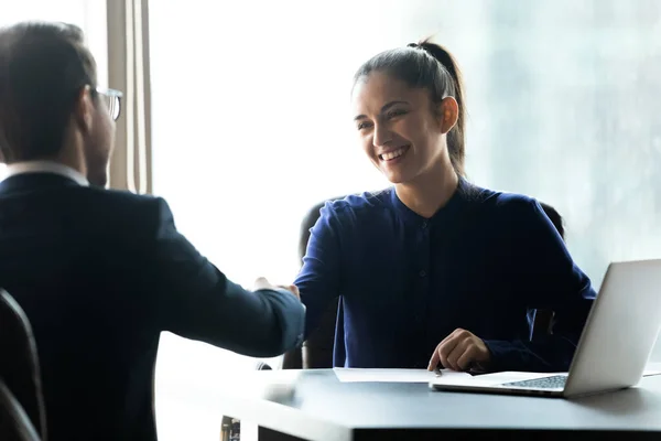 Усміхнені бізнесмени потискають руки, закриваючи угоду на зустрічі — стокове фото