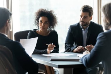 Takım toplantısı sırasında çok ırklı iş adamları beyin fırtınası yaptı.
