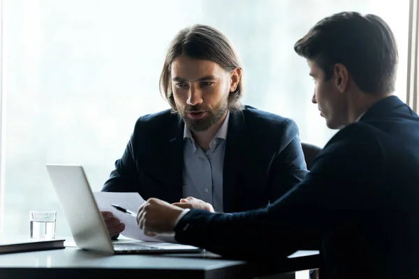 Konzentrierte Geschäftsleute arbeiten bei Bürotreffen am Laptop — Stockfoto