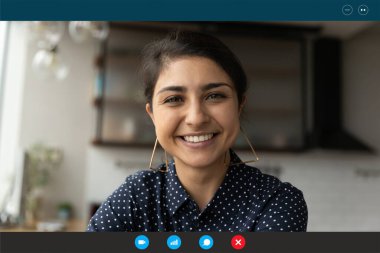 Gülümseyen güzel Hintli melez kadın web kamerasına bakıyor..