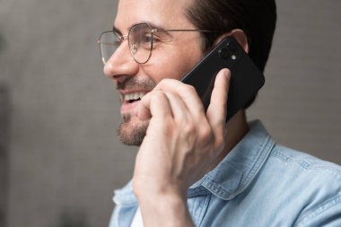 30 'lu yaşlardaki mutlu yakışıklı adam cep telefonuyla konuşuyor..