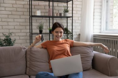 Mutlu, rahat, genç bir kadın internetten mal alıyor..