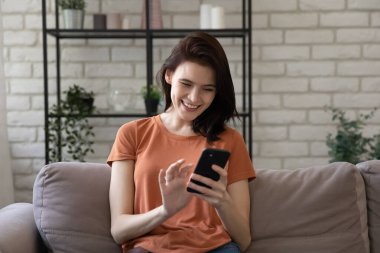 Evde cep telefonu kullanan mutlu beyaz kadın..