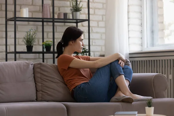 Unhappy anxious young caucasian woman sitting on couch. — Stock Photo, Image