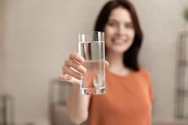 Close up focus on glass with water in female hands. — Stock Photo, Image