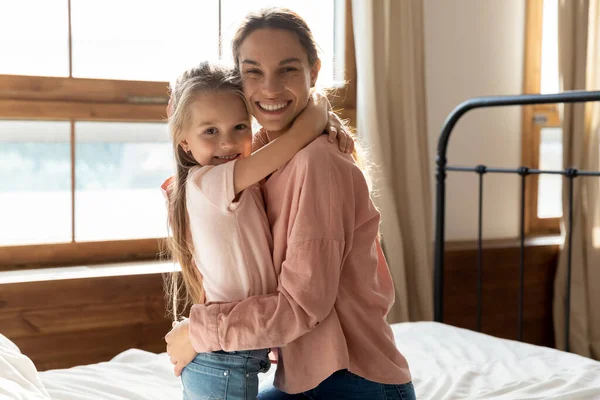 Mutter und kleine Tochter umarmen sich im Schlafzimmer — Stockfoto