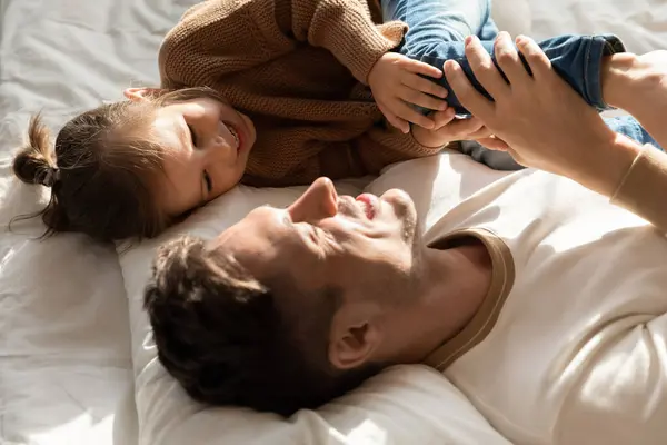 Papà trascorrere del tempo con la piccola figlia sdraiata insieme a letto — Foto Stock