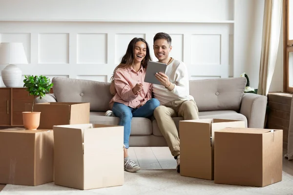 タブレットデバイスを使用して新しい家のための家具を購入するカップル — ストック写真